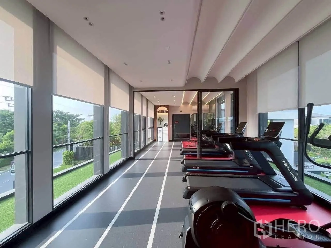 Townhouse for rent in Bang Phli, Samut Prakan - Glass-walled fitness room with treadmills and outdoor views.