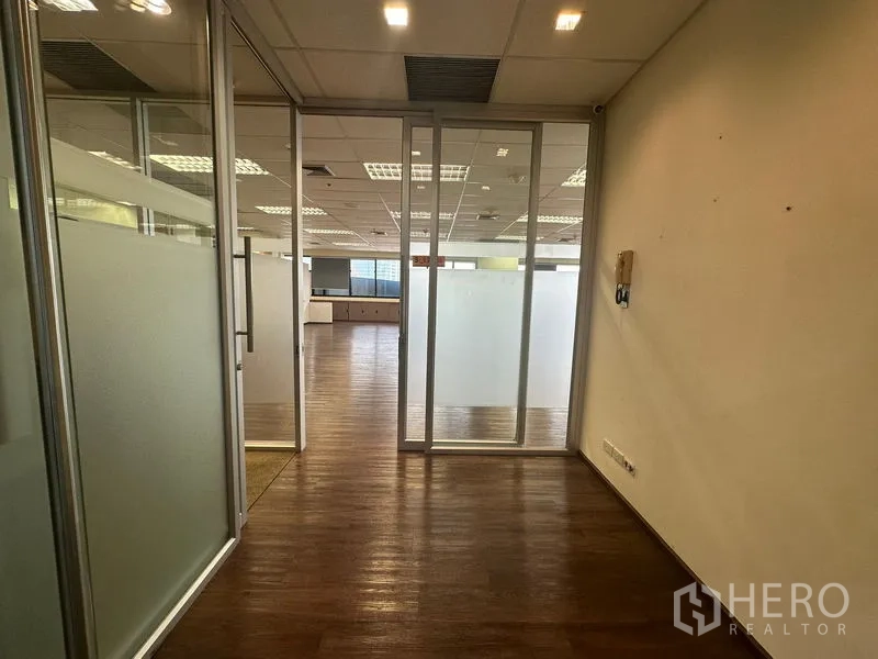 办公空间 出租在Bang Rak, Bangkok - 带磨砂玻璃隔断与木地板的办公室入口。