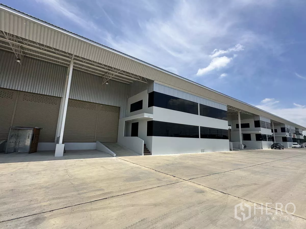 货栈 出租在Wang Noi, Phra Nakhon Si Ayutthaya - 成排仓库，黑框玻璃办公立面与宽敞卡车通道。