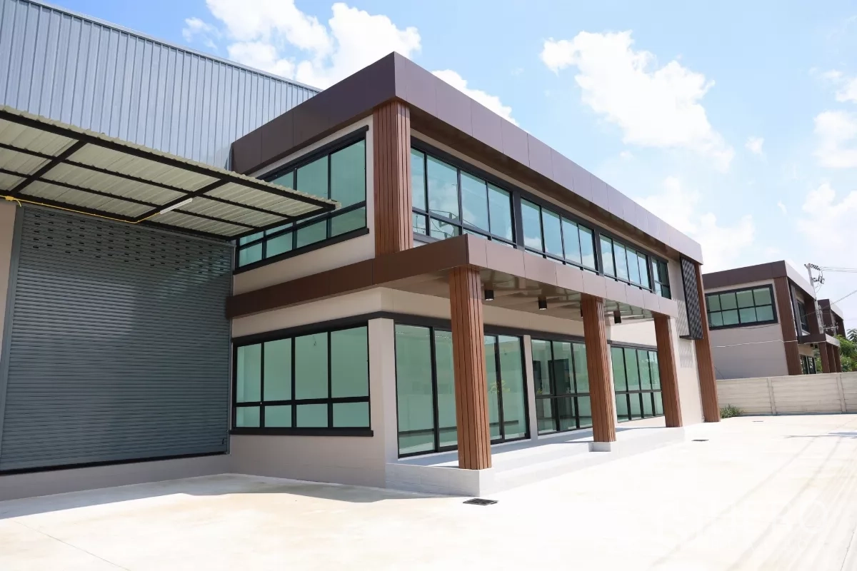Factory for rent or sale in Bang Len, Nakhon Pathom - Modern office block with floor-to-ceiling windows beside the warehouse loading bay and metal canopy.
