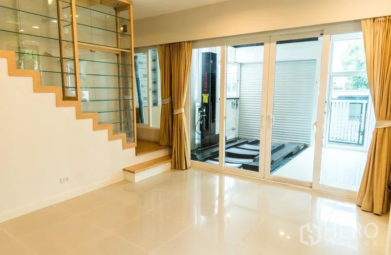 ทาวน์เฮาส์ ขายในWang Thonglang, Bangkok - พื้นที่นั่งเล่นเปิดโล่ง มีกระจกบานเลื่อน มองเห็นแท่นลิฟต์จอดรถ