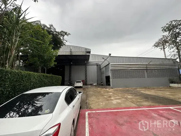 工厂 出租在Bang Bua Thong, Nonthaburi - 金属外墙厂房正面，宽阔车道与停车位。