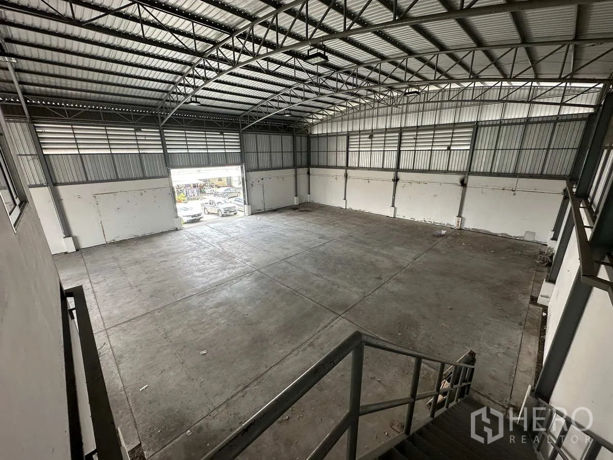 Factory for rent in Pathum Thani - View from mezzanine stairs across wide production floor to the front shutter.