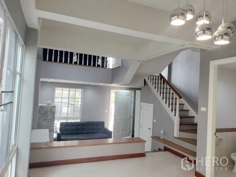 ทาวน์เฮาส์ ให้เช่าในBueng Kum, Bangkok - โถงทางเข้าฝ้าเพดานสูงพร้อมบันได โคมไฟแขวน และพื้นกระเบื้อง