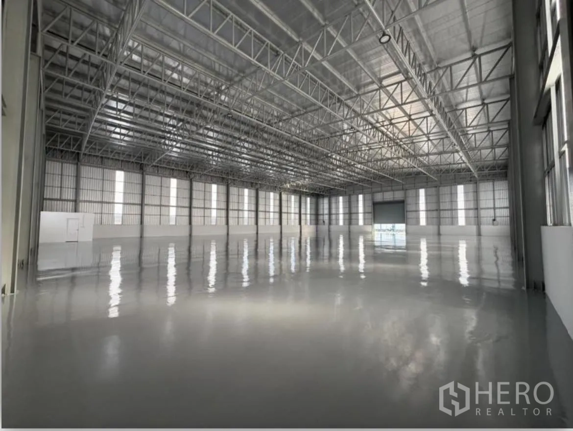 Warehouse for rent in Bang Khun Thian, Bangkok - Spacious warehouse interior with steel trusses and tall wall panels.
