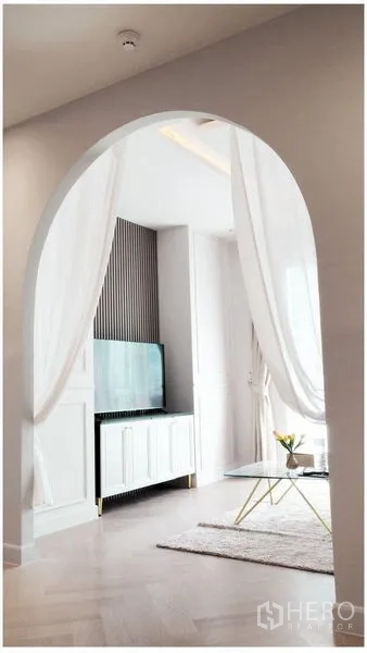 คอนโด ให้เช่าหรือขาย - ซุ้มโค้งม่านบาง นำสู่ตู้ทีวีและมุมนั่งเล่น