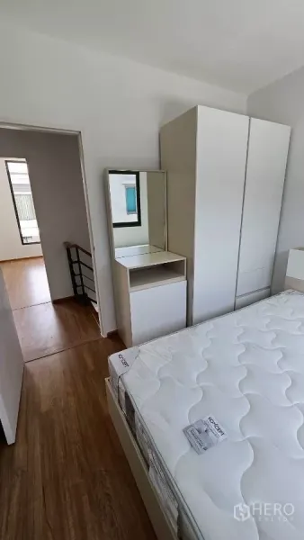 ทาวน์เฮาส์ ให้เช่าในBang Phli, Samut Prakan - มุมห้องนอนเห็นตู้เสื้อผ้า โต๊ะเครื่องแป้งพร้อมกระจก และประตูออกสู่โถง