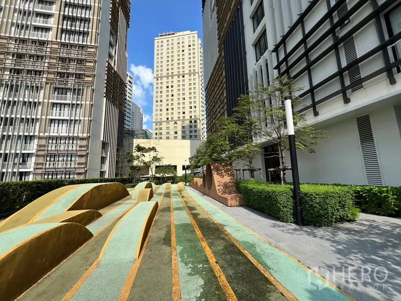 คอนโด ขาย - ลานกลางแจ้งจัดภูมิทัศน์เป็นลูกคลื่น รายล้อมด้วยตึกสูง