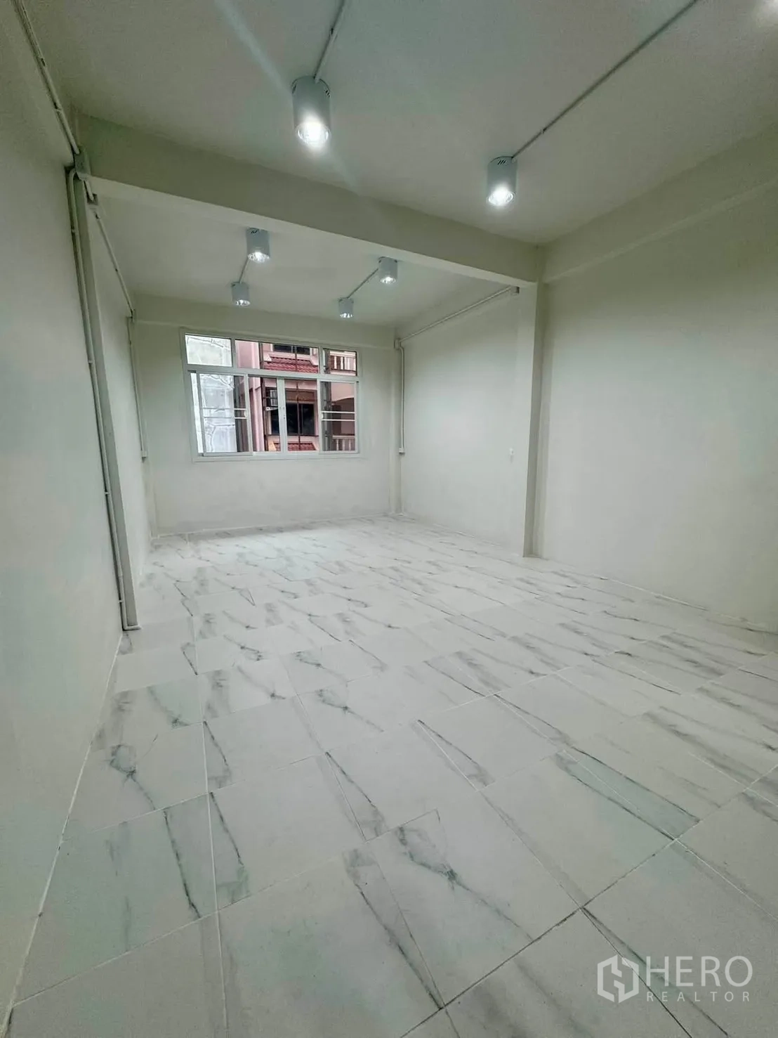 Shophouse for rent in Sathon, Bangkok - Open-plan room with ceiling spotlights and large window.