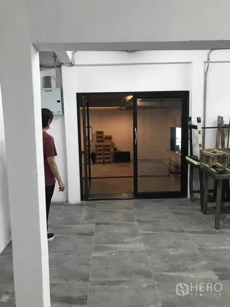 Office Space for rent in Watthana, Bangkok - Open office area with sliding glass doors and exposed conduits for an industrial look.