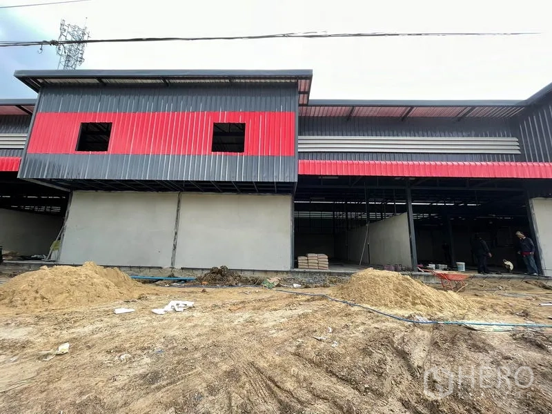 货栈 出租在Pathum Thani - 仓库中央立面，超大开口，前方进行土方作业。