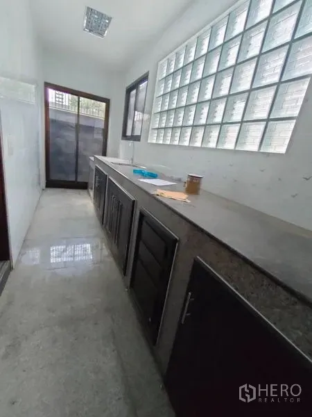 带办公室的家 出租在Pathum Wan, Bangkok - 采光明亮的茶水间，长台面与玻璃砖墙，并有门通向小露台。