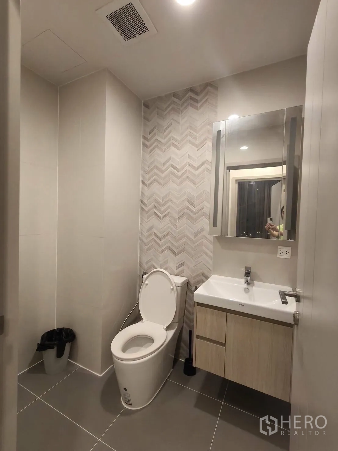 คอนโด for rent in Khlong Toei, Bangkok - ห้องน้ำที่สองผนังลายก้างปลา พร้อมอ่างล้างหน้า กระจก และโถสุขภัณฑ์