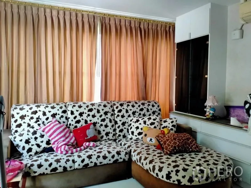 บ้าน ขายในThawi Watthana, Bangkok - มุมนั่งเล่นอบอุ่น โซฟาลาย ผ้าม่านเต็มผืน และตู้โชว์บิลท์อิน