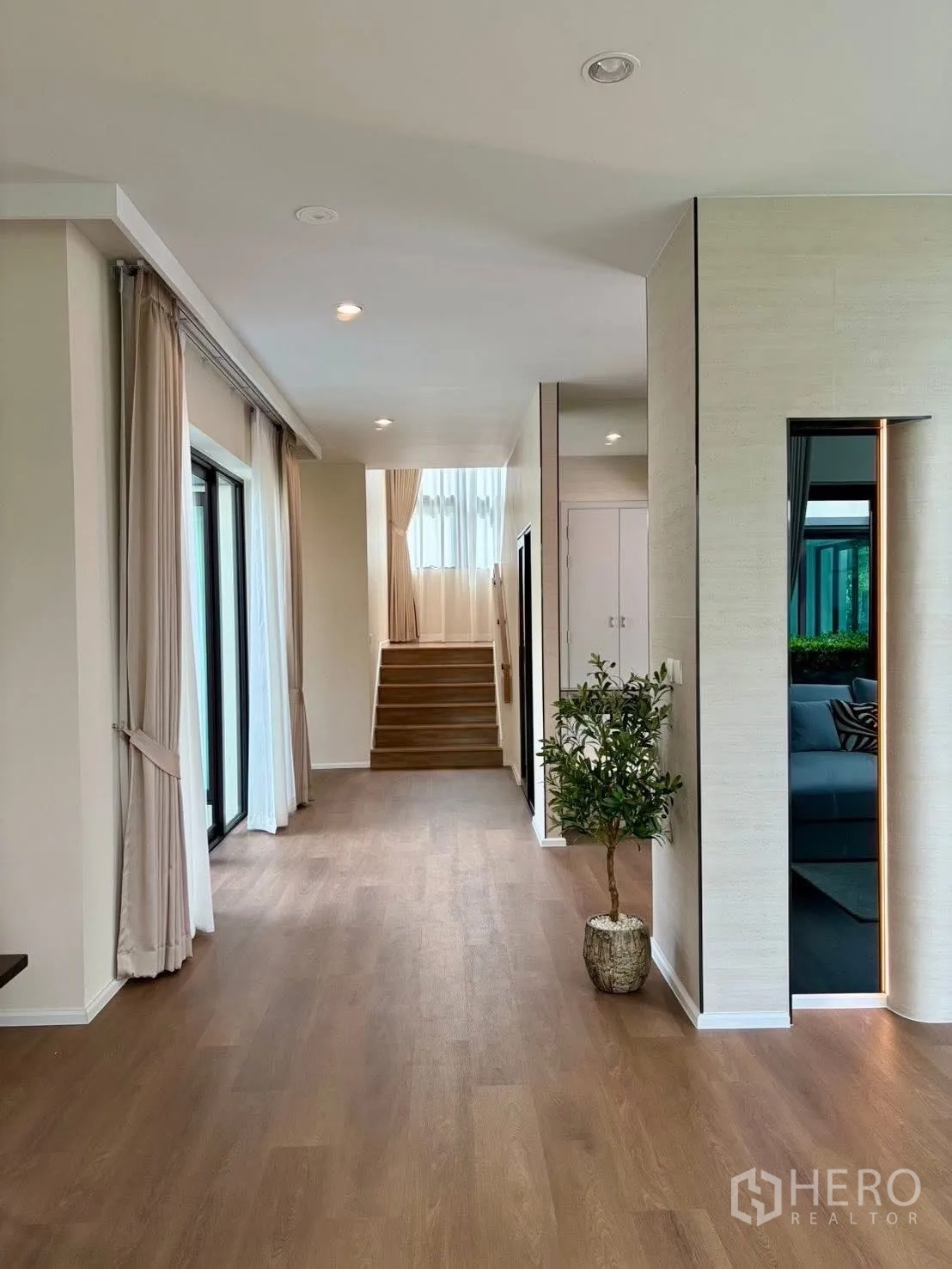 Detached House for rent in Bang Phli, Samut Prakan - Wide hallway with large windows, wood flooring and steps leading to the upper level.