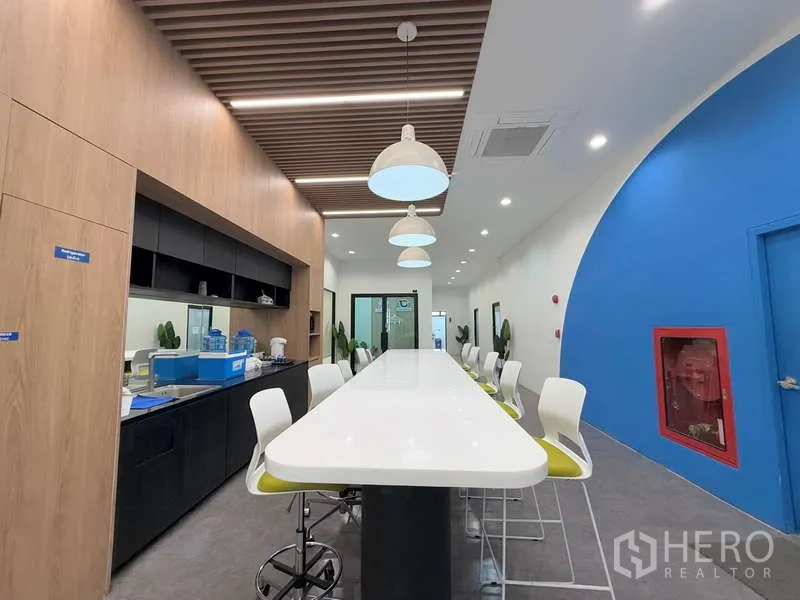 Office Space for rent in Huai Khwang, Bangkok - Shared pantry and lounge featuring an extra‑long island counter, bar stools, pendant lights and wood accents.