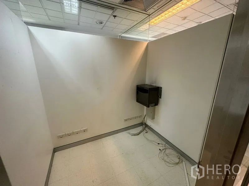 Office Space for rent - Small server or IT room with wall-mounted equipment and exposed cabling.