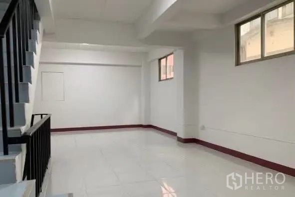 Home Office for rent in Sathon, Bangkok - Open white-walled room with windows and a stair rail.