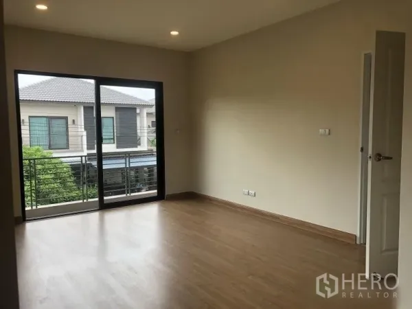 Detached House for sale in Bang Phli, Samut Prakan - Bright upstairs bedroom with wood floor and sliding glass doors to balcony