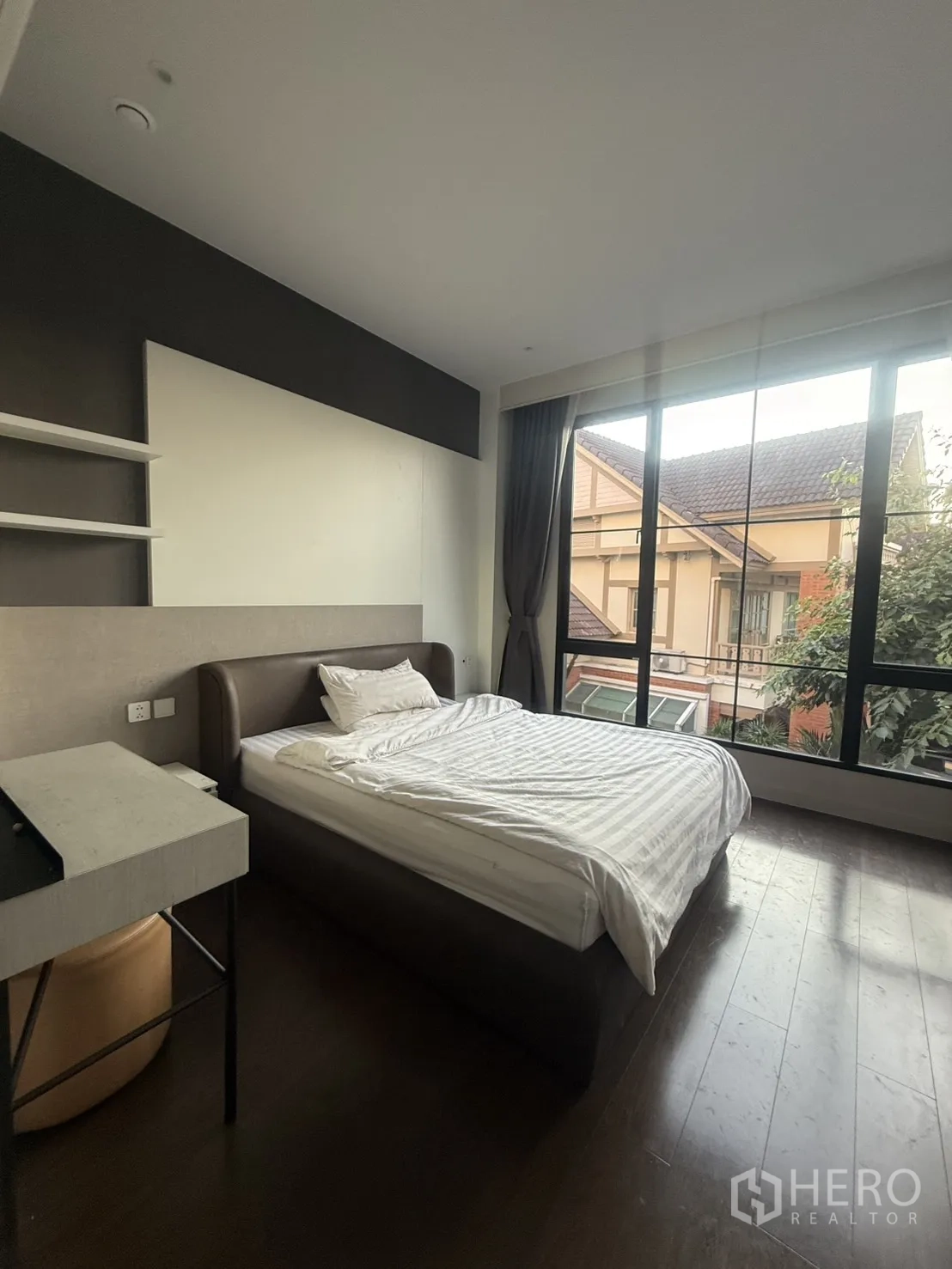 Detached House for rent in Saphan Sung, Bangkok - Guest bedroom with large window overlooking neighboring roofs and trees.