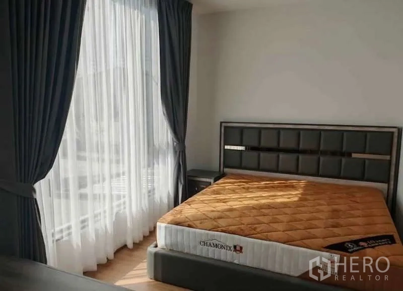 ทาวน์เฮาส์ ให้เช่าในBang Phli, Samut Prakan - ห้องนอนใหญ่ หน้าต่างบานกว้าง ม่านโปร่ง เตียงหัวเตียงบุหนัง และที่นอน