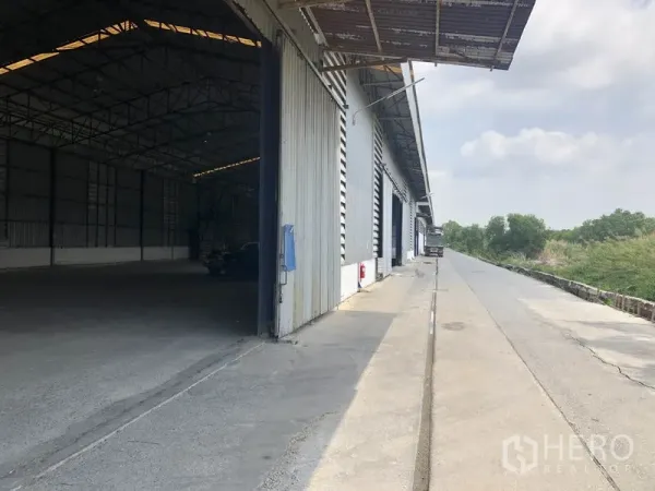 货栈 出租在Pathum Thani - 大型钢结构仓库外部装卸区，宽阔卡车通道与雨棚。