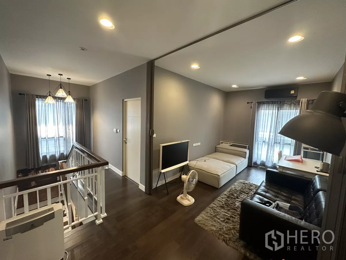 บ้าน ให้เช่าหรือขายในLam Luk Ka, Pathum Thani - ห้องนั่งเล่นชั้นบนข้างบันได มีเดย์เบด โซฟา โคมแขวน และทางออกสู่ระเบียง