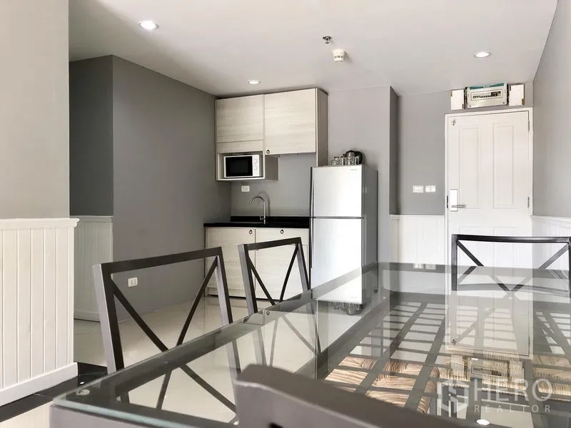 คอนโด ให้เช่าในKhlong Toei, Bangkok - ครัวขนาดกะทัดรัดพร้อมไมโครเวฟ ตู้เก็บของ และตู้เย็นขนาดใหญ่ติดกับโต๊ะอาหาร