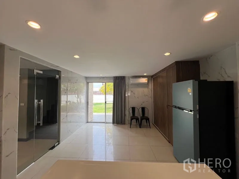 Detached House for sale in Mueang Pathum Thani, Pathum Thani - Kitchen rear section with sliding door to the garden and marble-look walls.