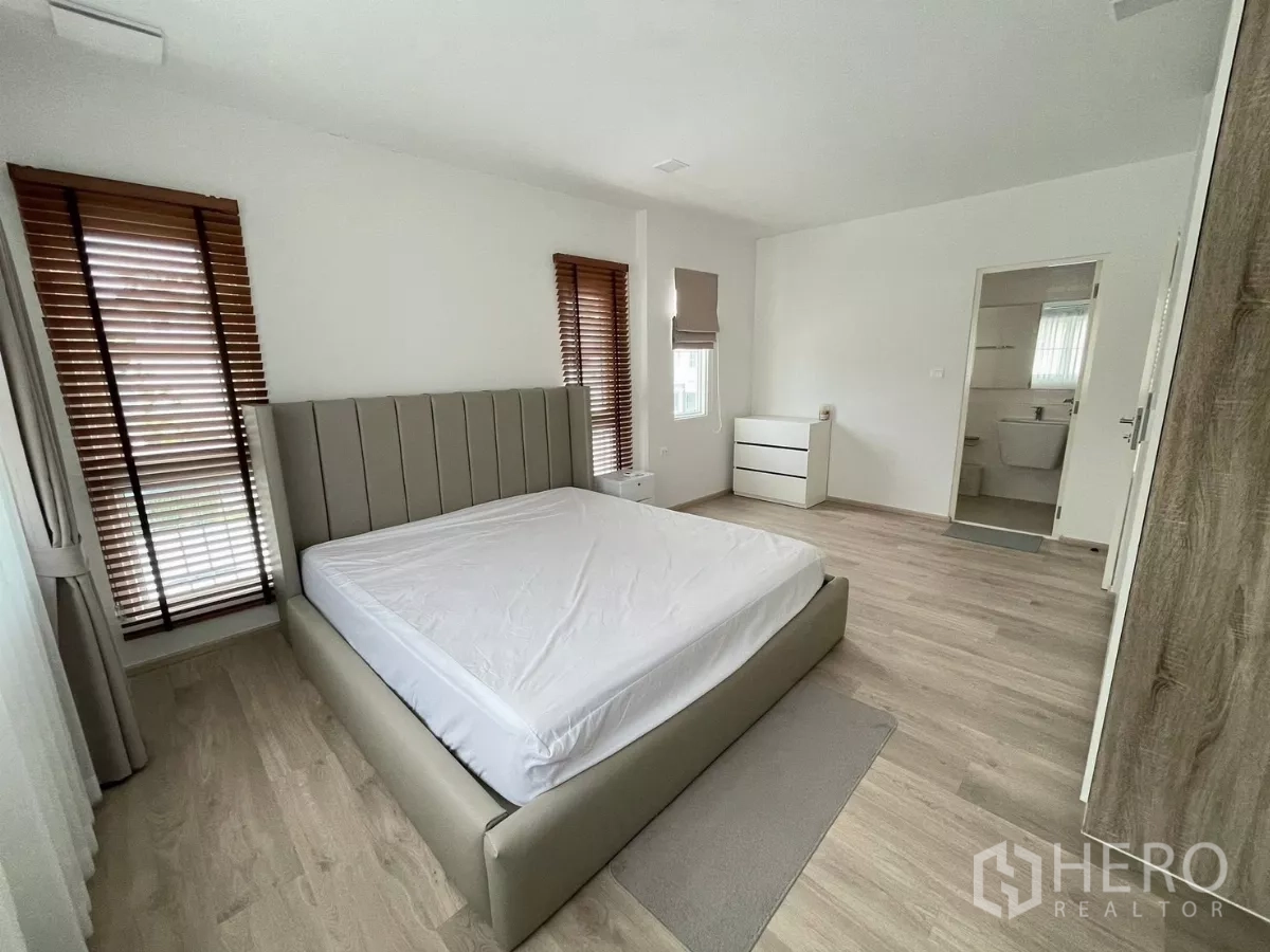 Detached House for rent or sale in Bang Phli, Samut Prakan - Master bedroom view with entrance to ensuite bathroom and bedside cabinet.