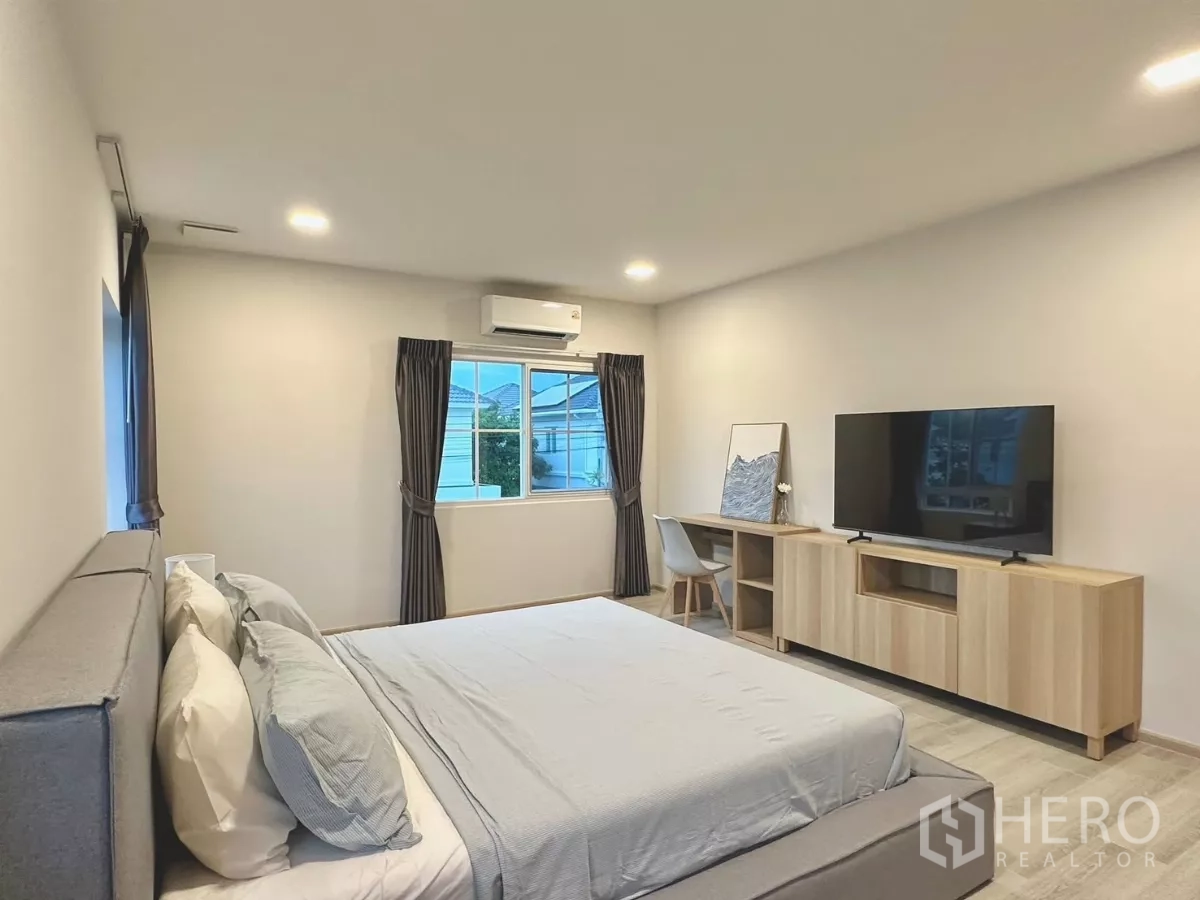 独立式住宅 出租在Bang Phli, Samut Prakan - 宽大的主卧，配特大床、电视柜与多扇窗户。