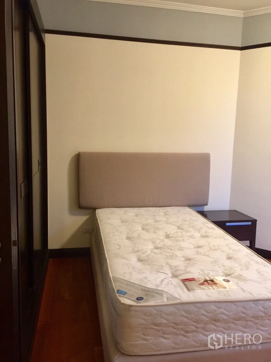 Condominium for rent in Pathum Wan, Bangkok - Compact guest bedroom with single bed, upholstered headboard and built-in wardrobe.