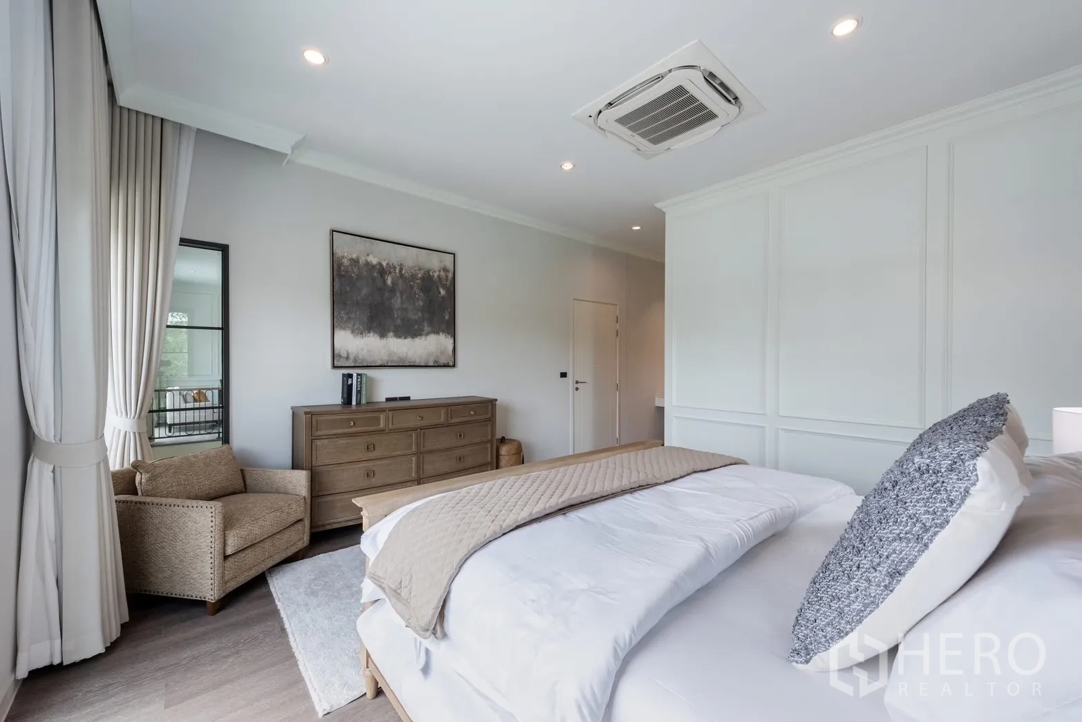 Detached House for rent or sale in Bang Phli, Samut Prakan - Comfortable bedroom with armchair, long dresser, and ceiling cassette air unit.