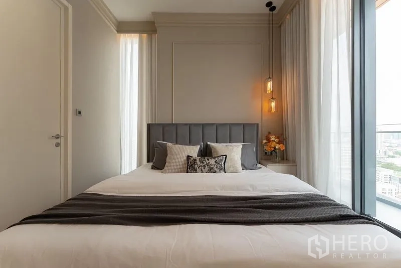 公寓 出租在Watthana, Bangkok - 主卧正面视角，软包床头与通往阳台的落地窗。