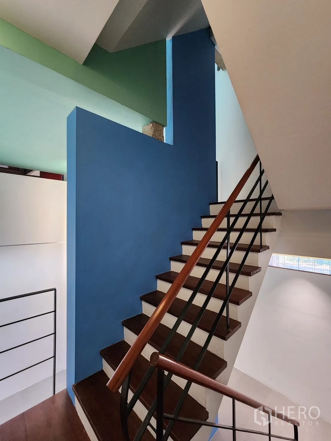 家庭办公室 for rent in Chatuchak, Bangkok - 室内楼梯，木踏步、金属栏杆与蓝色点缀墙。