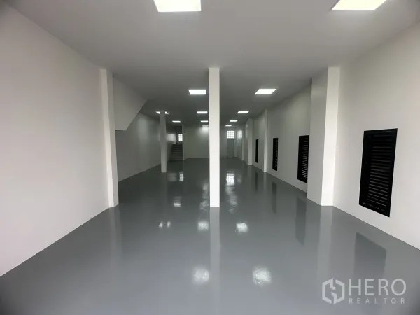 货栈 出售在Khlong Luang, Pathum Thani - 仓库一层内部，环氧地坪、白色墙面与立柱，照明明亮。