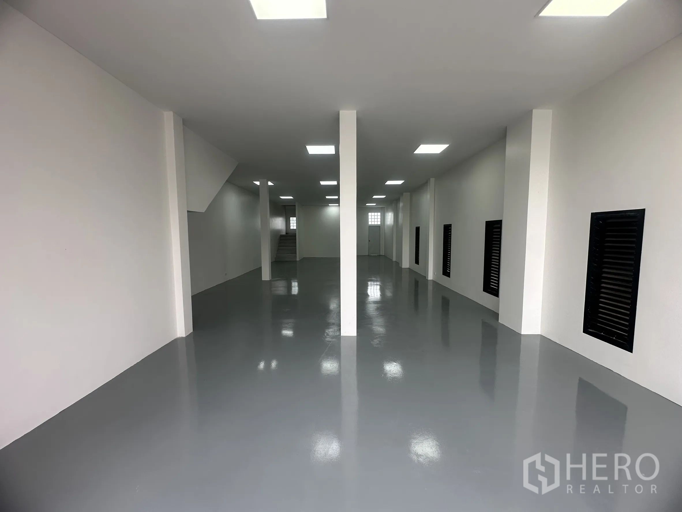 货栈 出售在Khlong Luang, Pathum Thani - 仓库一层内部，环氧地坪、白色墙面与立柱，照明明亮。