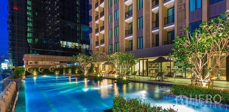 คอนโด ให้เช่าในChatuchak, Bangkok - ด้านหน้าคอนโดติดดาดฟ้าสระว่ายน้ำสว่างไสว มีต้นไม้และที่นั่ง