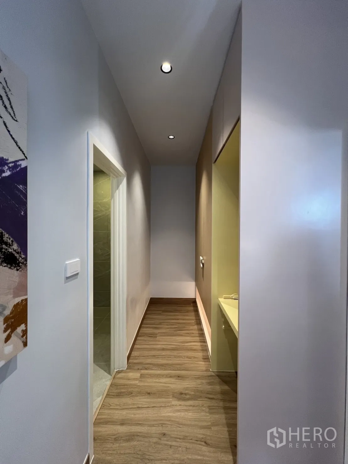 Townhouse for rent in Mueang Samut Prakan, Samut Prakan - Narrow corridor with recessed ceiling lights and wood-look floors.