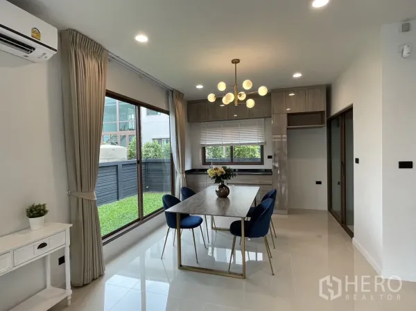 Detached House for rent in Bang Kapi, Bangkok - Dining space beside sliding glass doors overlooking the side garden and built-in kitchen.