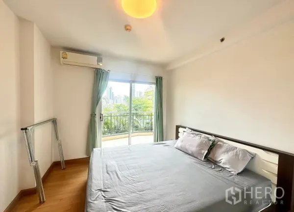 คอนโด ให้เช่าในHuai Khwang, Bangkok - ห้องนอนหลักมีประตูกระจกออกไประเบียง มองเห็นต้นไม้และวิวสกายไลน์