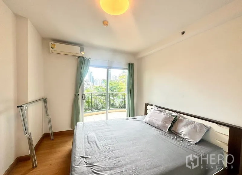 คอนโด ให้เช่าในHuai Khwang, Bangkok - ห้องนอนหลักมีประตูกระจกออกไประเบียง มองเห็นต้นไม้และวิวสกายไลน์