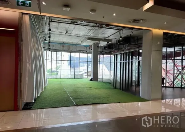 零售空间 出租在Watthana, Bangkok - 开放式零售铺位，落地窗、裸露天花与人工草坪地面，位于现代商场内