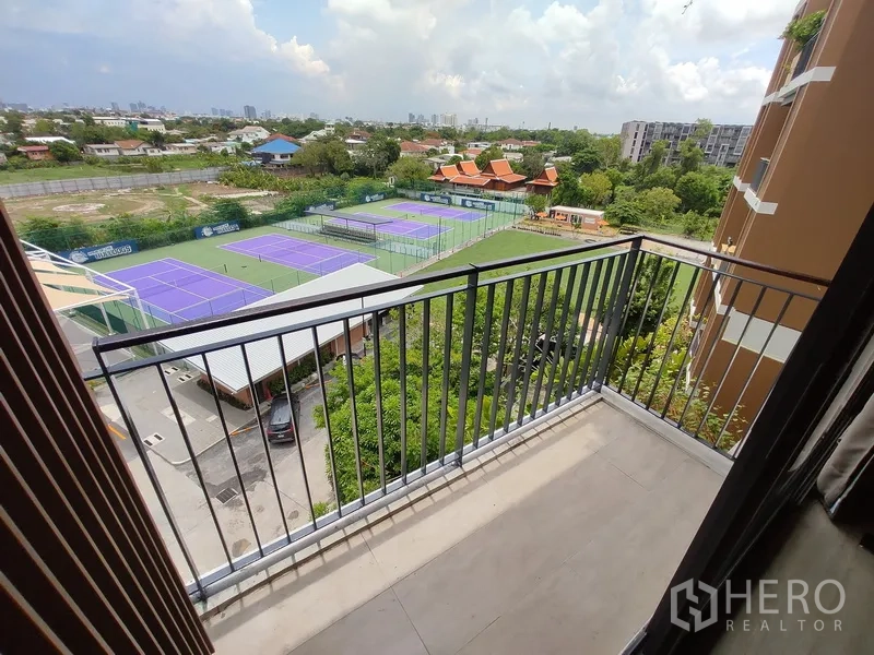 Condominium for rent in Watthana, Bangkok - Private balcony overlooking tennis courts and a green neighborhood.