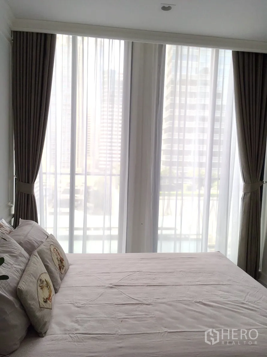 คอนโด ให้เช่าในPathum Wan, Bangkok - ห้องนอนสว่าง เตียงคู่ ผ้าม่านโปร่ง และหน้าต่างบานสูงวิวเมือง
