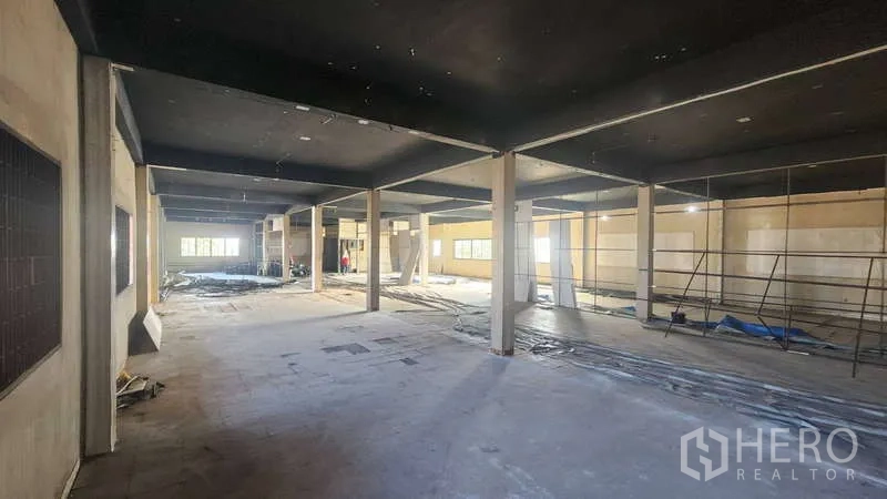 工厂 出租在Chom Thong, Bangkok - 大型车间，黑色天花与支撑立柱、窗户。