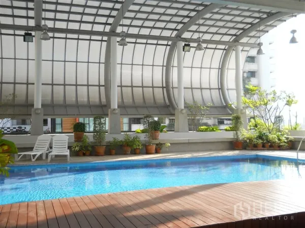 คอนโด ให้เช่าในWatthana, Bangkok - สระว่ายน้ำคลุมหลังคาพร้อมดาดไม้ กระถางต้นไม้ และเก้าอี้อาบแดด