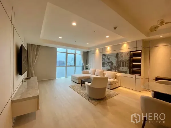 คอนโด ให้เช่าในKhlong Luang, Pathum Thani - ห้องนั่งเล่นโซฟา L พร้อมตู้วางทีวี ผนังตกแต่ง และวิวสกายไลน์แบบพาโนรามา