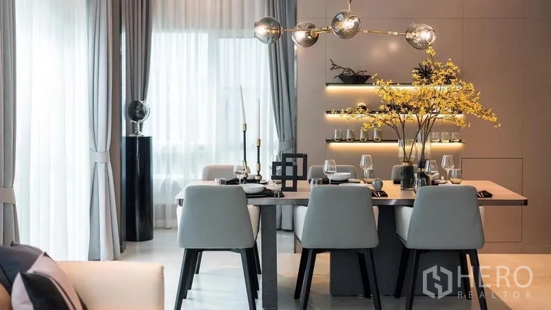 Detached House for rent in Prawet, Bangkok - Stylish dining table for six under globe pendant lighting with backlit shelves.