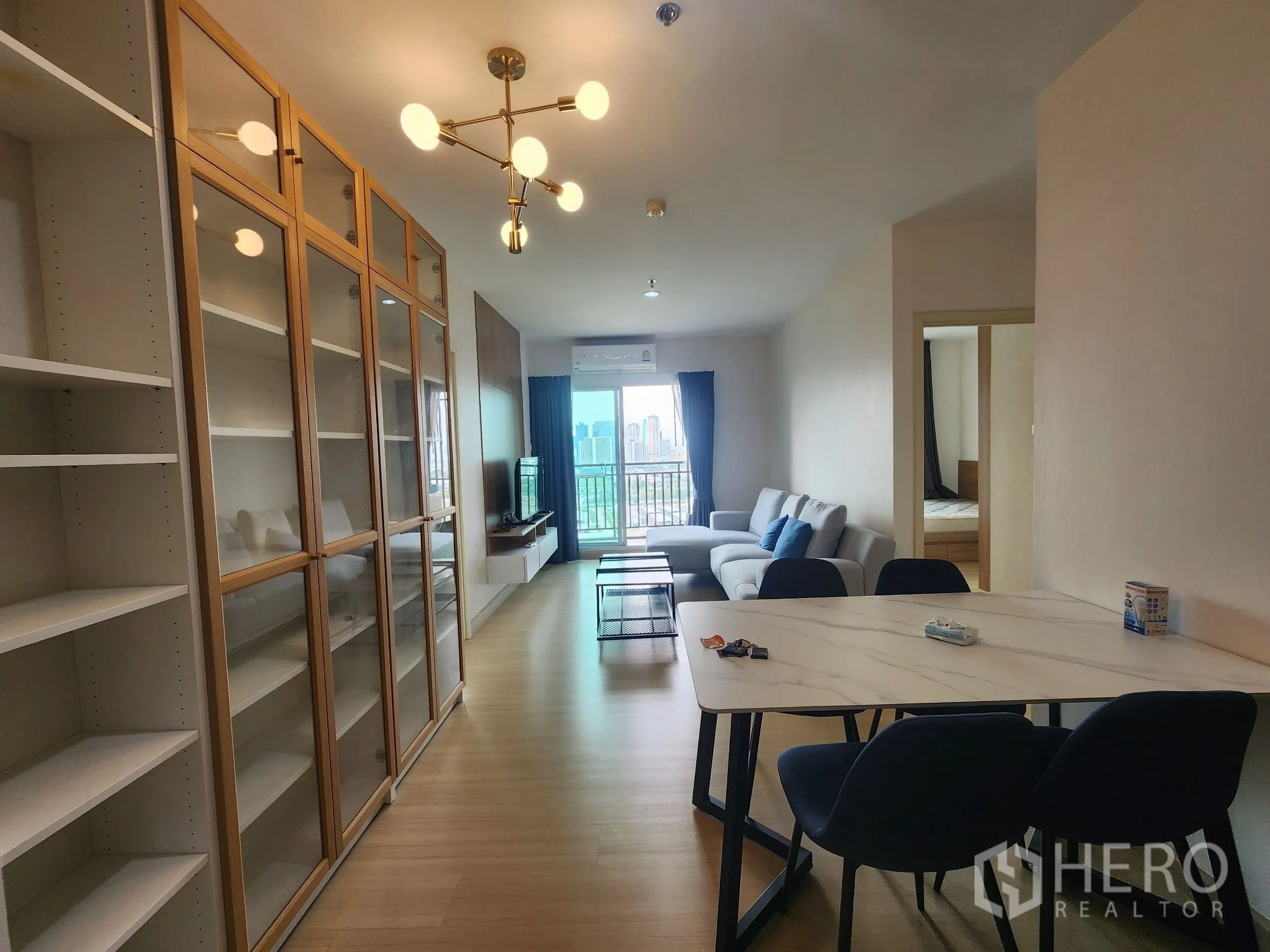 คอนโด for rent in Huai Khwang, Bangkok - แปลนเปิดโล่งยาว มีผนังตู้เก็บของ โต๊ะทานอาหาร และทางเข้าห้องนอนกับระเบียง